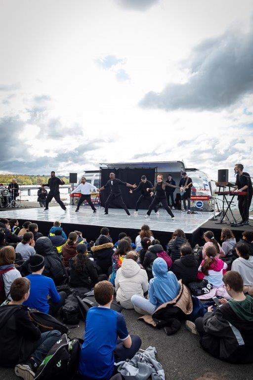 Spectacle de danse hip-hop sur scène devant un public assis en plein air