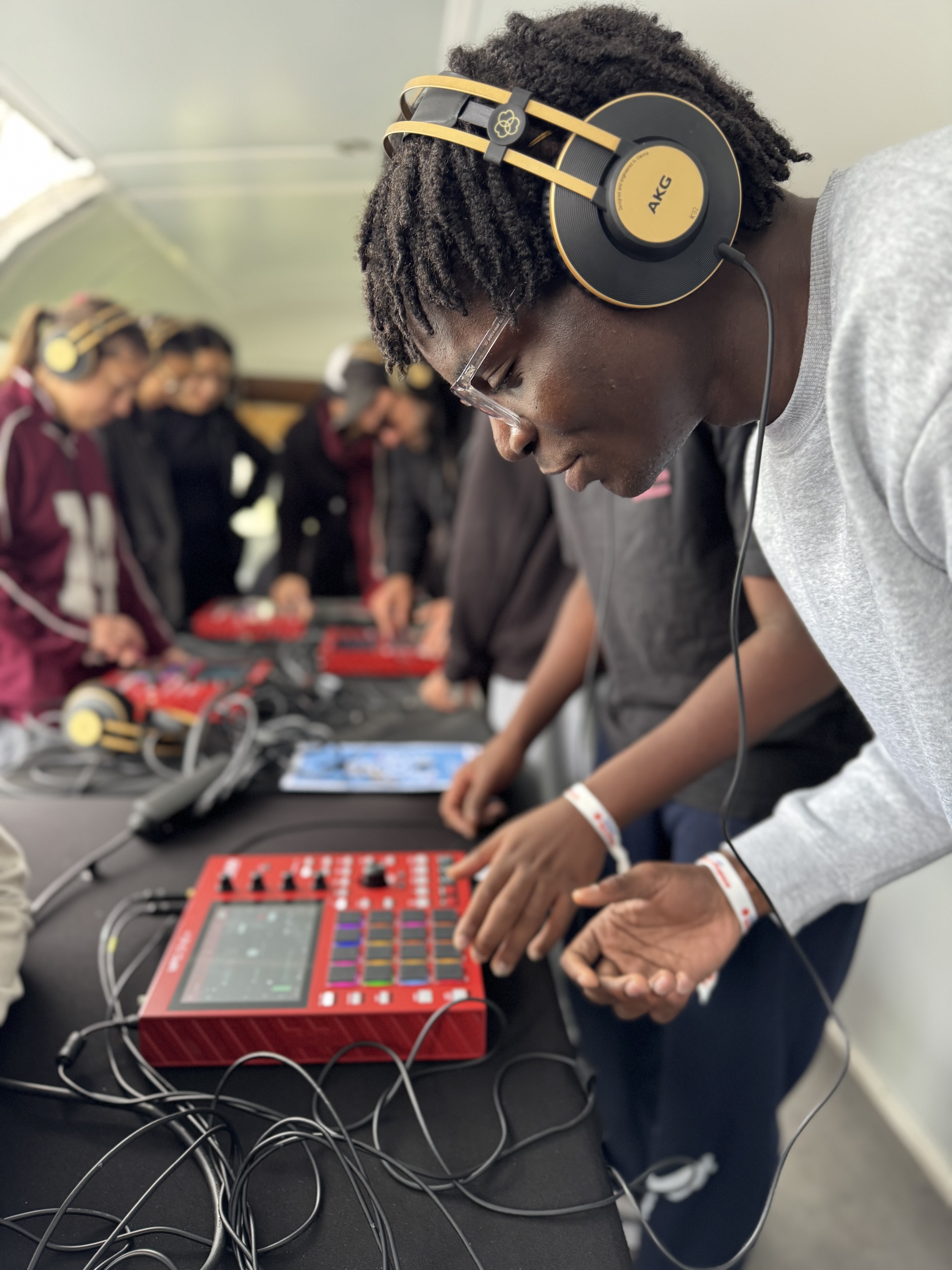 Atelier beatmaking : jeunes au casque sur des pads de production musicale