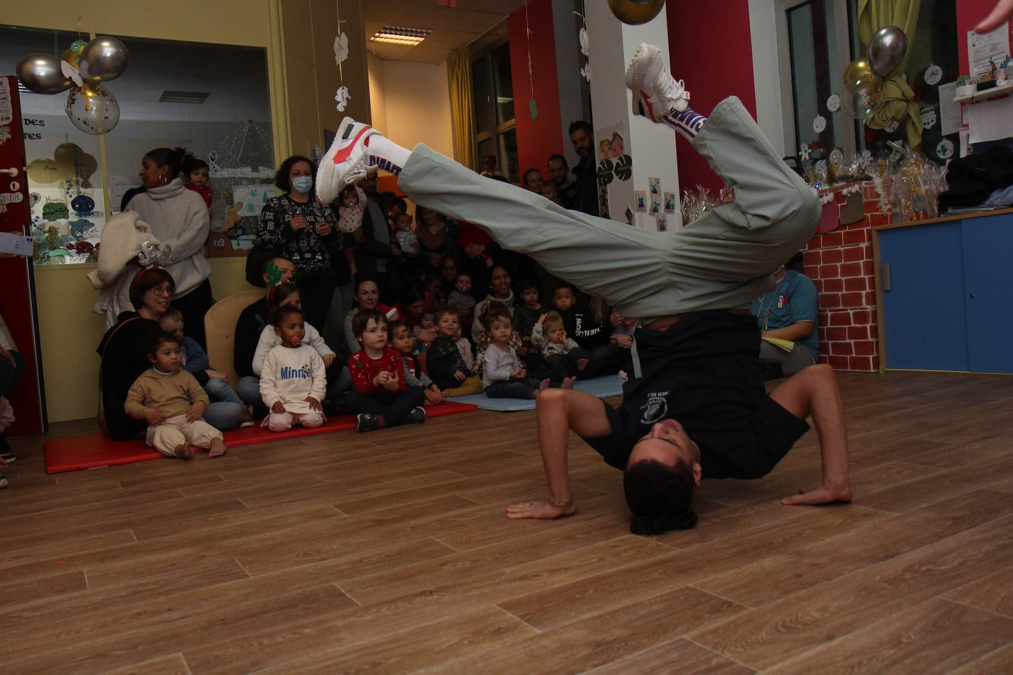 Breakeur en freeze devant un groupe de jeunes enfants attentifs