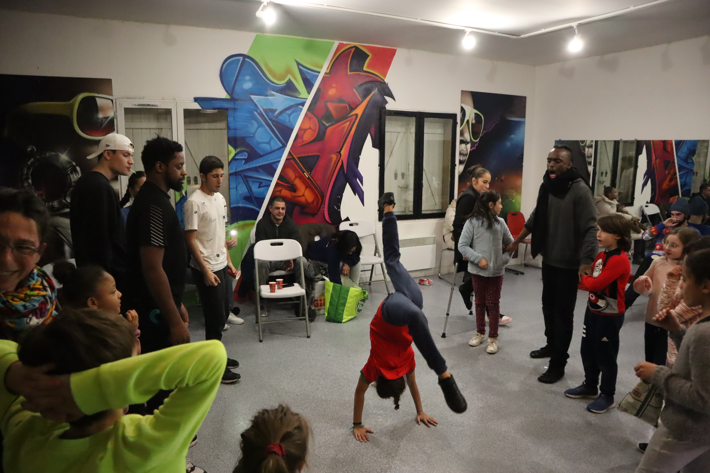 Enfant en équilibre sur les mains au centre d'un cercle de danse hip-hop