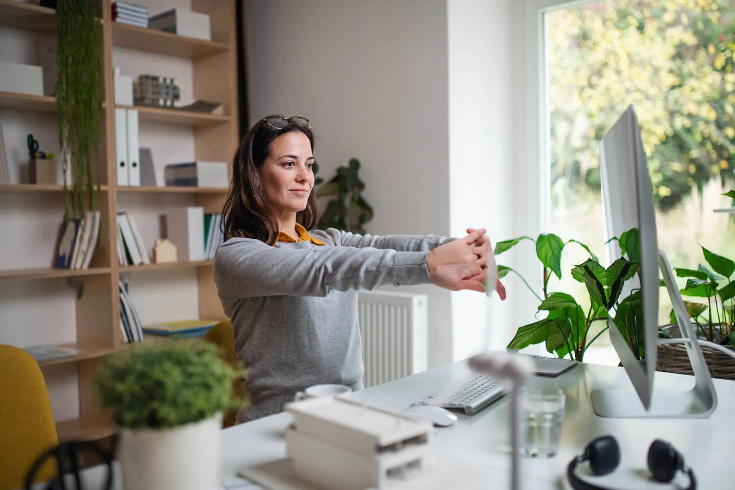 Women stretching working on her computer from home