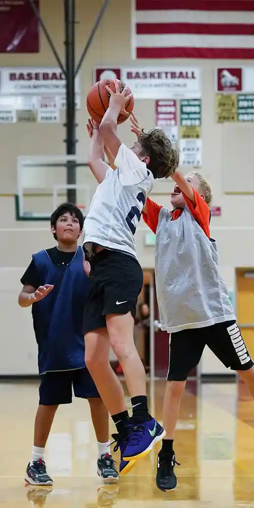 Boys running on a basketball court during tryouts