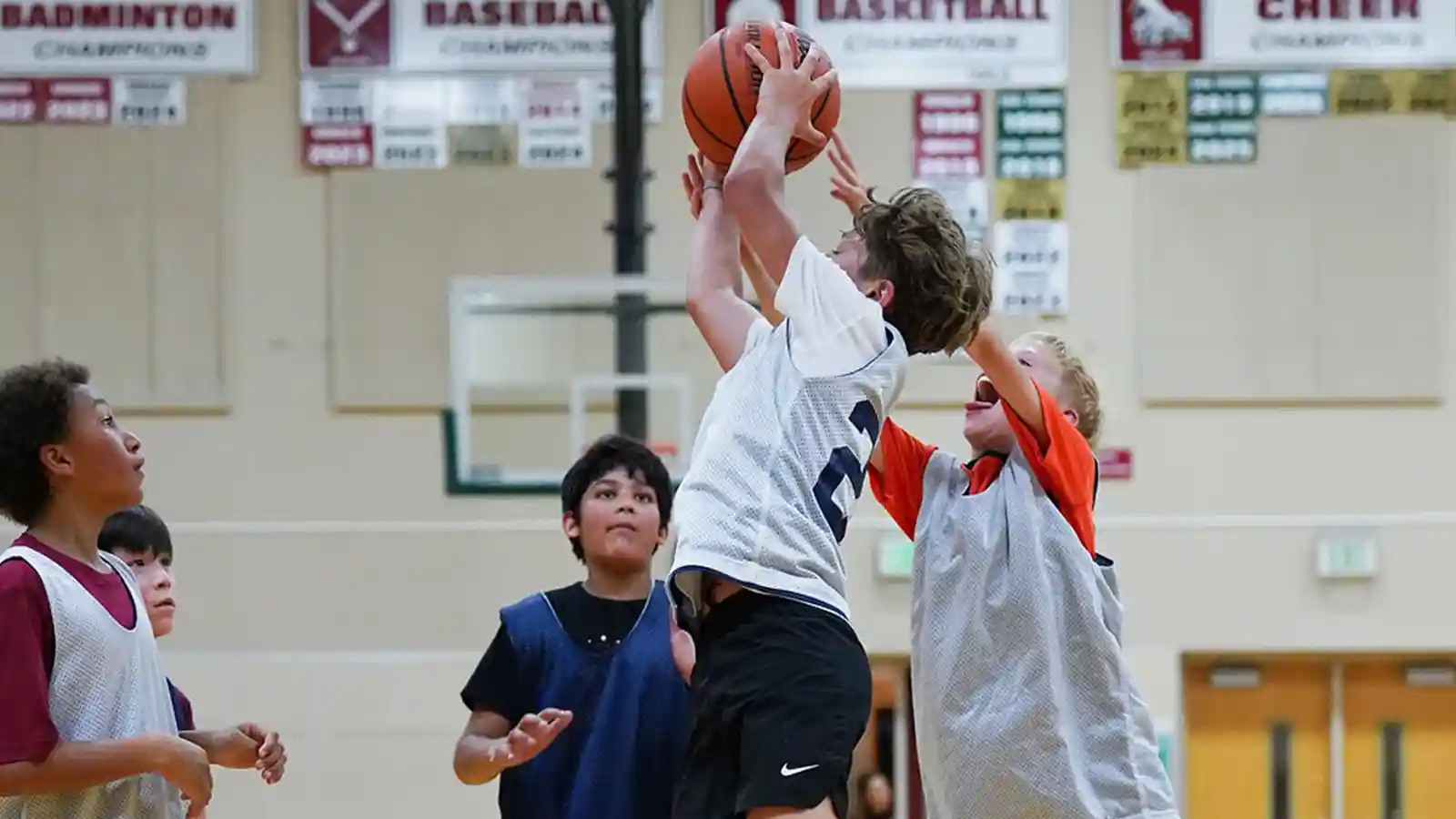 Boys running on a basketball court during tryouts