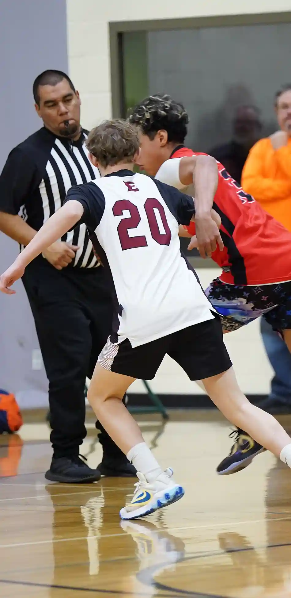 A boy shooting a basketball over defenders
