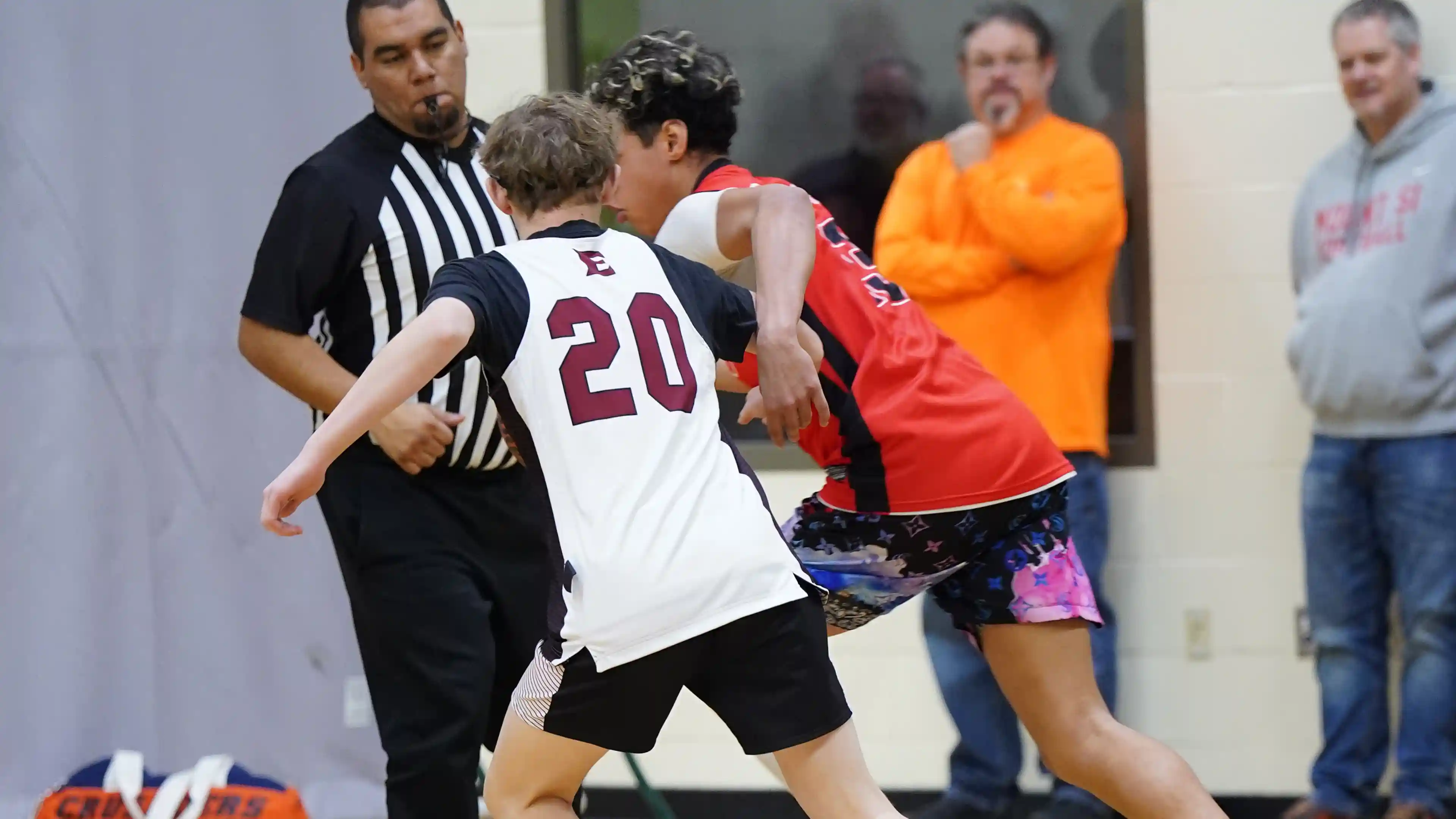 A boy shooting a basketball over defenders