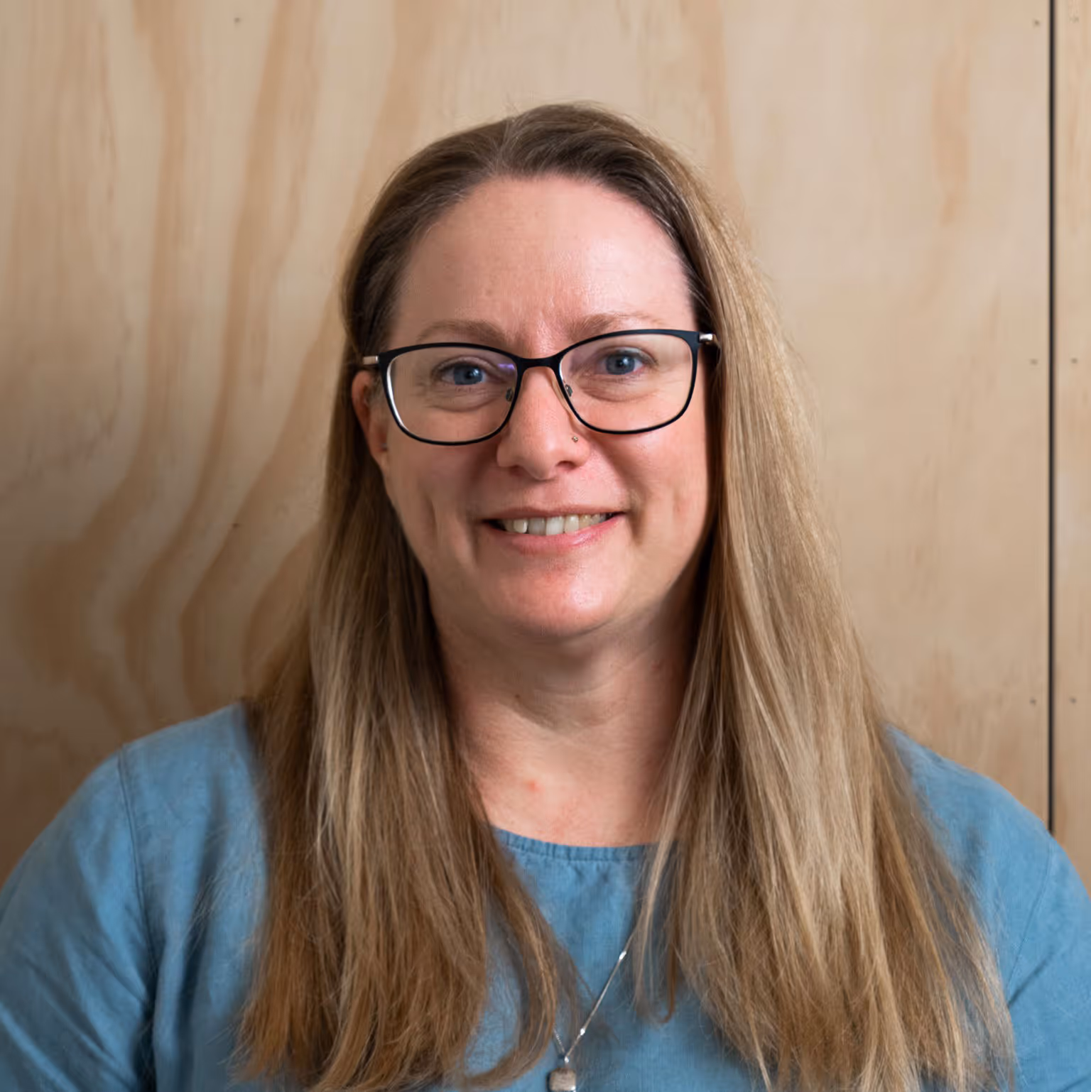 Rachel smiling at the camera, wearing a blue top