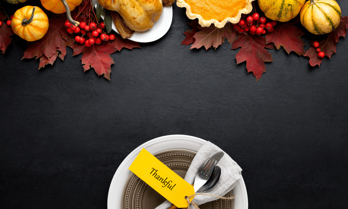 Black background with fall leaves and Thanksgiving foods lining the top of the image and a plate with a tag reading "thankful" at the bottom of the image.