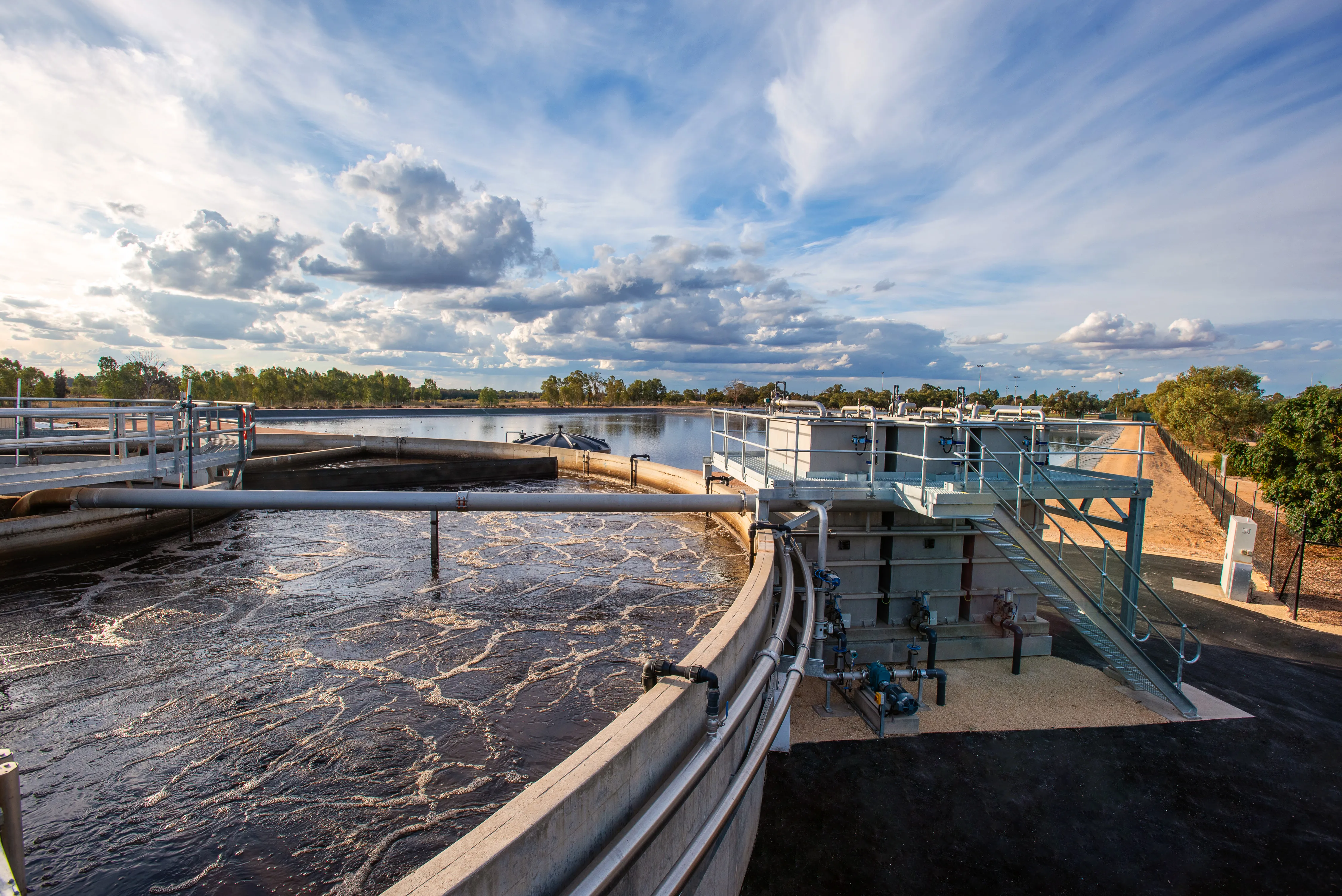 Wastewater treatment clarifier under a cloudy sky