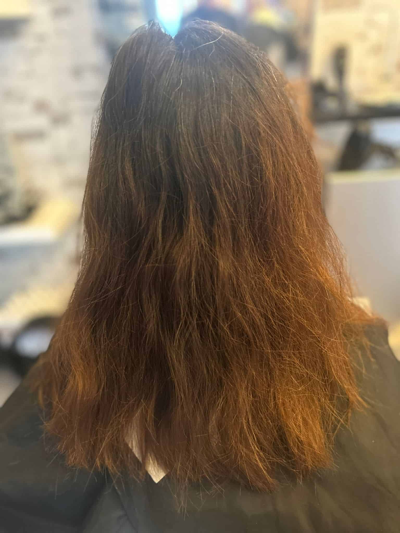 Photo of the back of a head with long, damaged, and brittle hair before the QUEEN KERATINTHERAPY by KYANA was performed.