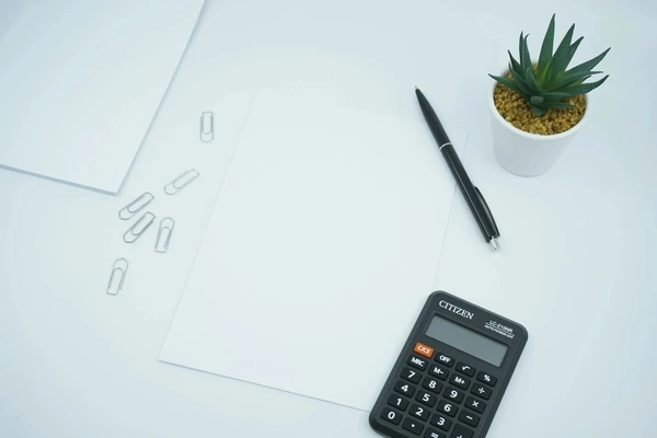 white sheet of paper and a calculator on a table