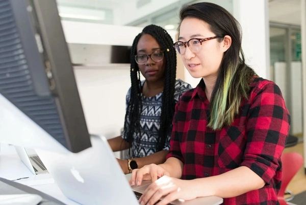two people working on laptops in the office