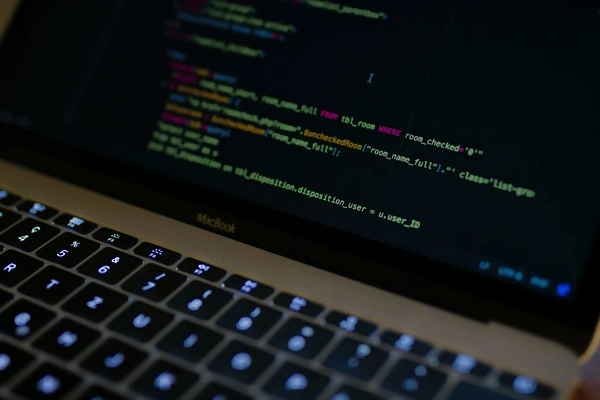 laptop with a programming code on the screen