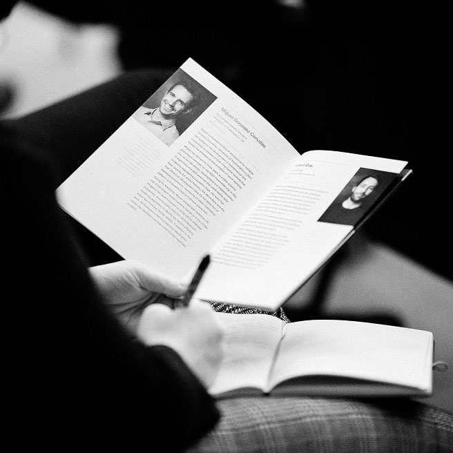 Person reading Faculty demo day booklet