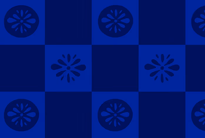 A swatch of the blue variation of the brand pattern, which is a navy and cobalt checkerboard with flower and medallion brand illustrations used inside each of the lighter squares in alternating rows. This design was inspired by traditional Mexican tiles.