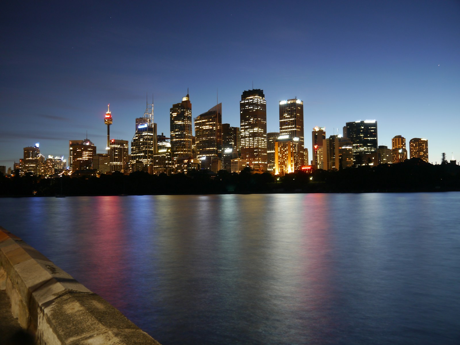 Sydney CBD office towers at dusk reflected across the harbour