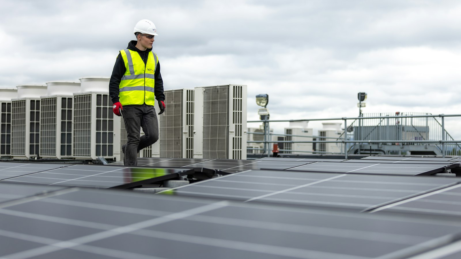 Maintenance contractor walking between rooftop HVAC plant on a commercial building