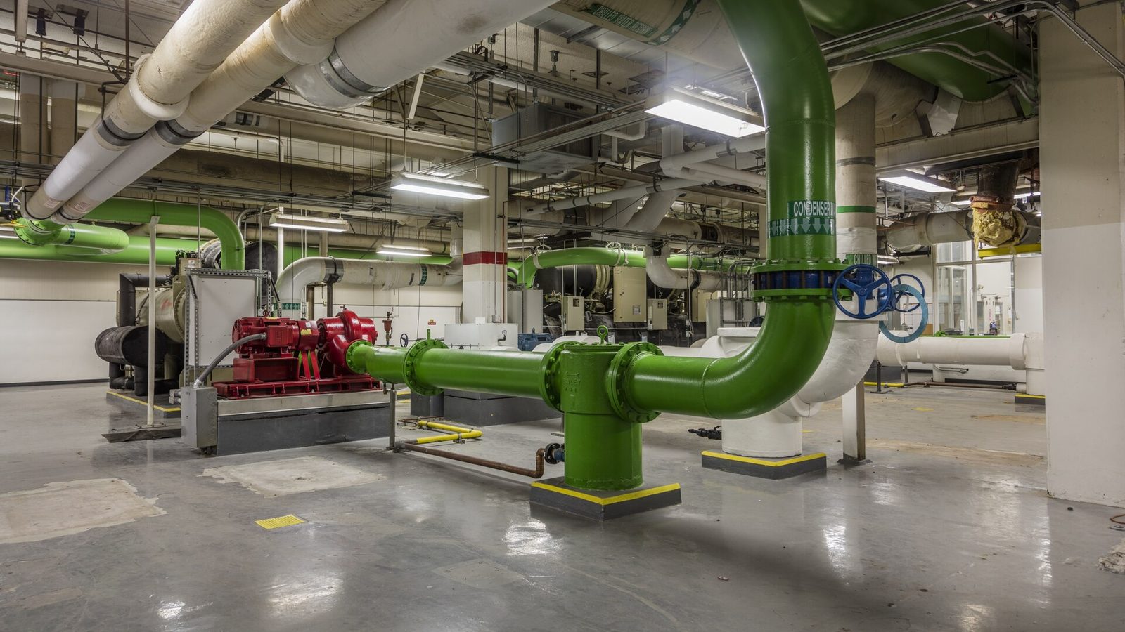 Central plant room in a US federal building with chillers, pumps and green chilled water pipework