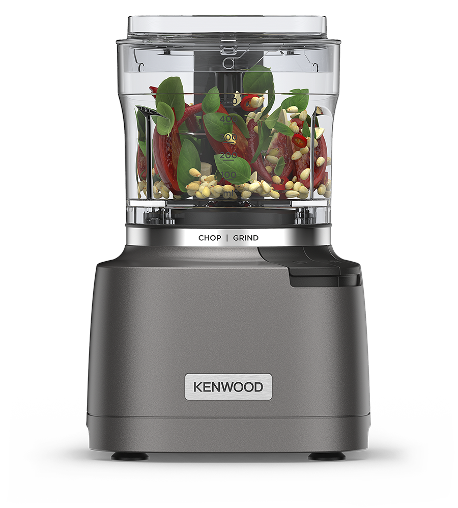 Kenwood food processor filled with chopped tomatoes, basil leaves, and pine nuts ready to chop.