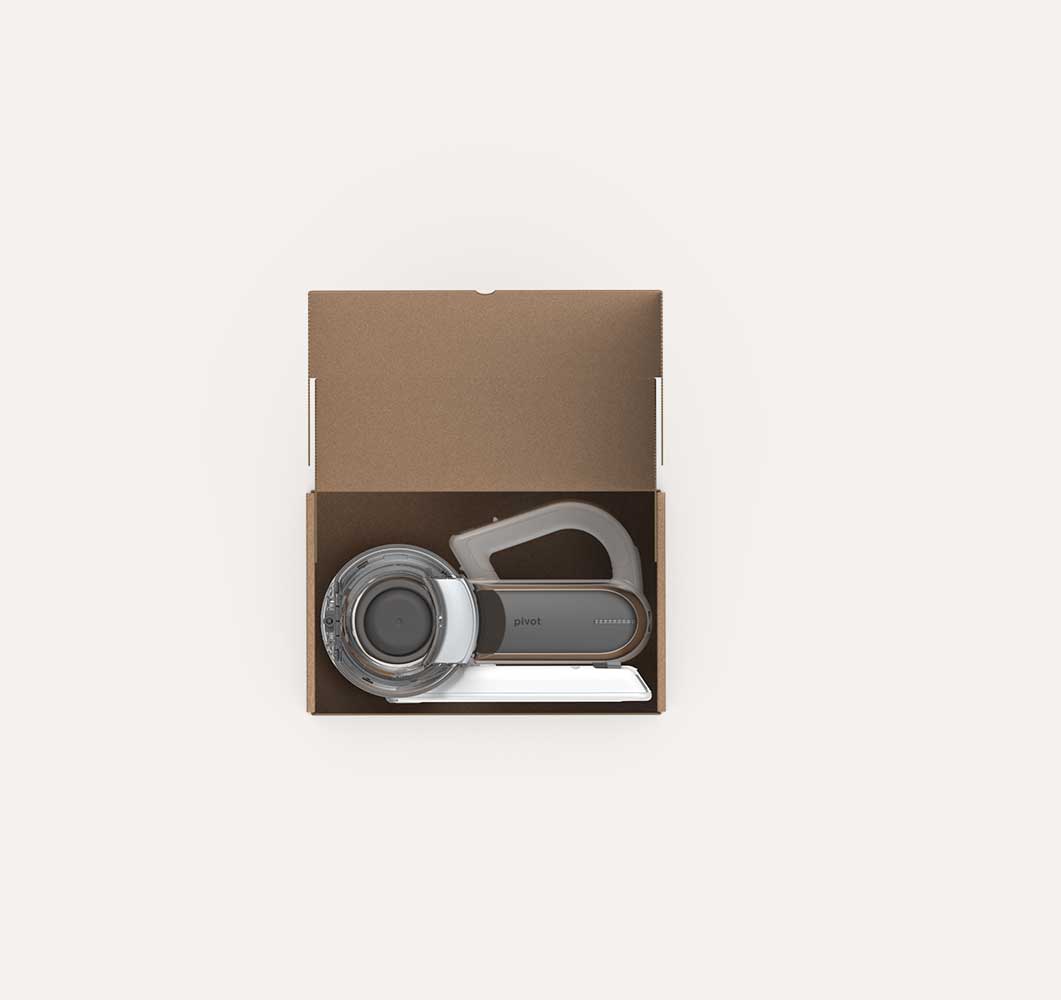 Top view of an open brown cardboard box containing a compact vacuum cleaner with a transparent circular dustbin and a gray handle labeled 'pivot'.