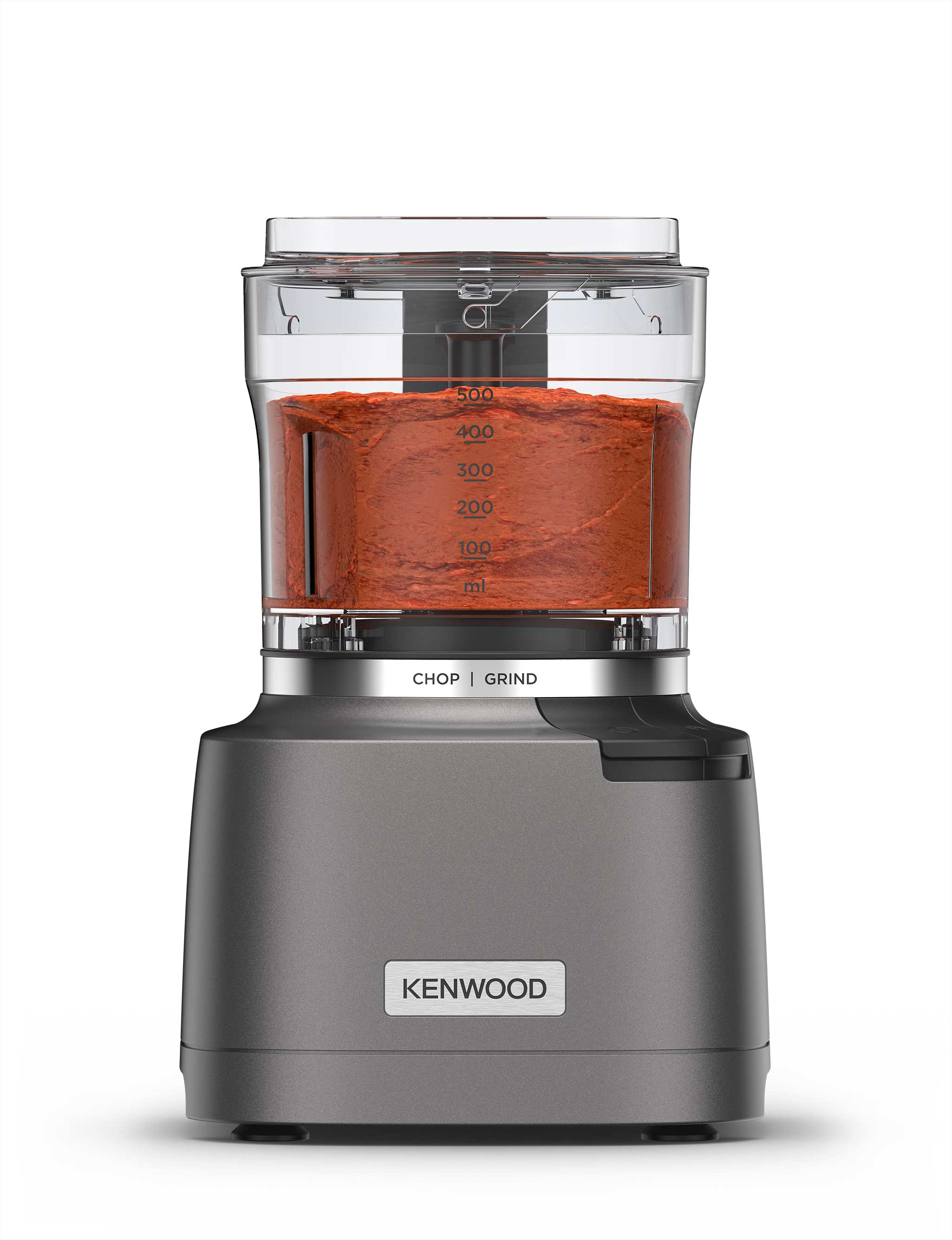 Kenwood kitchen appliance with a transparent container filled with blended red pesto, labelled with measurements and featuring chop and grind settings.