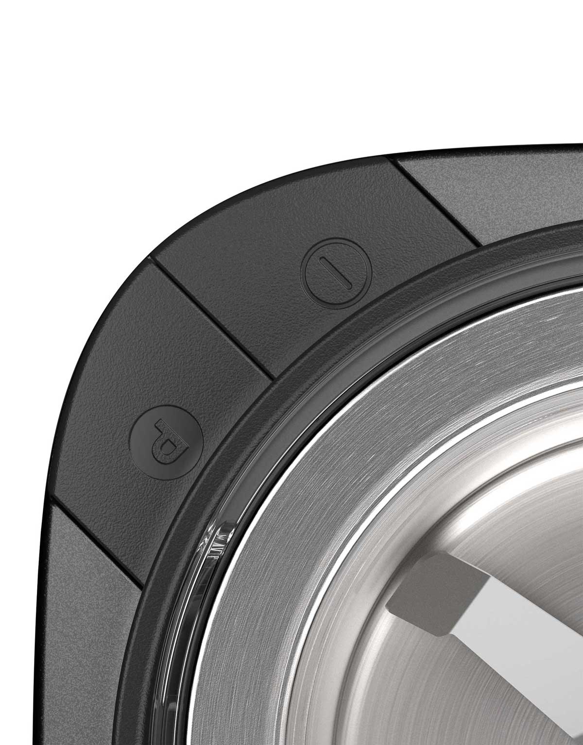 Close-up of a blender grinder with a circular metallic brushed finish, bordered by black segmented material with small embossed symbols 'P' and 'I' showing the power and pulse icons on the control buttons.
