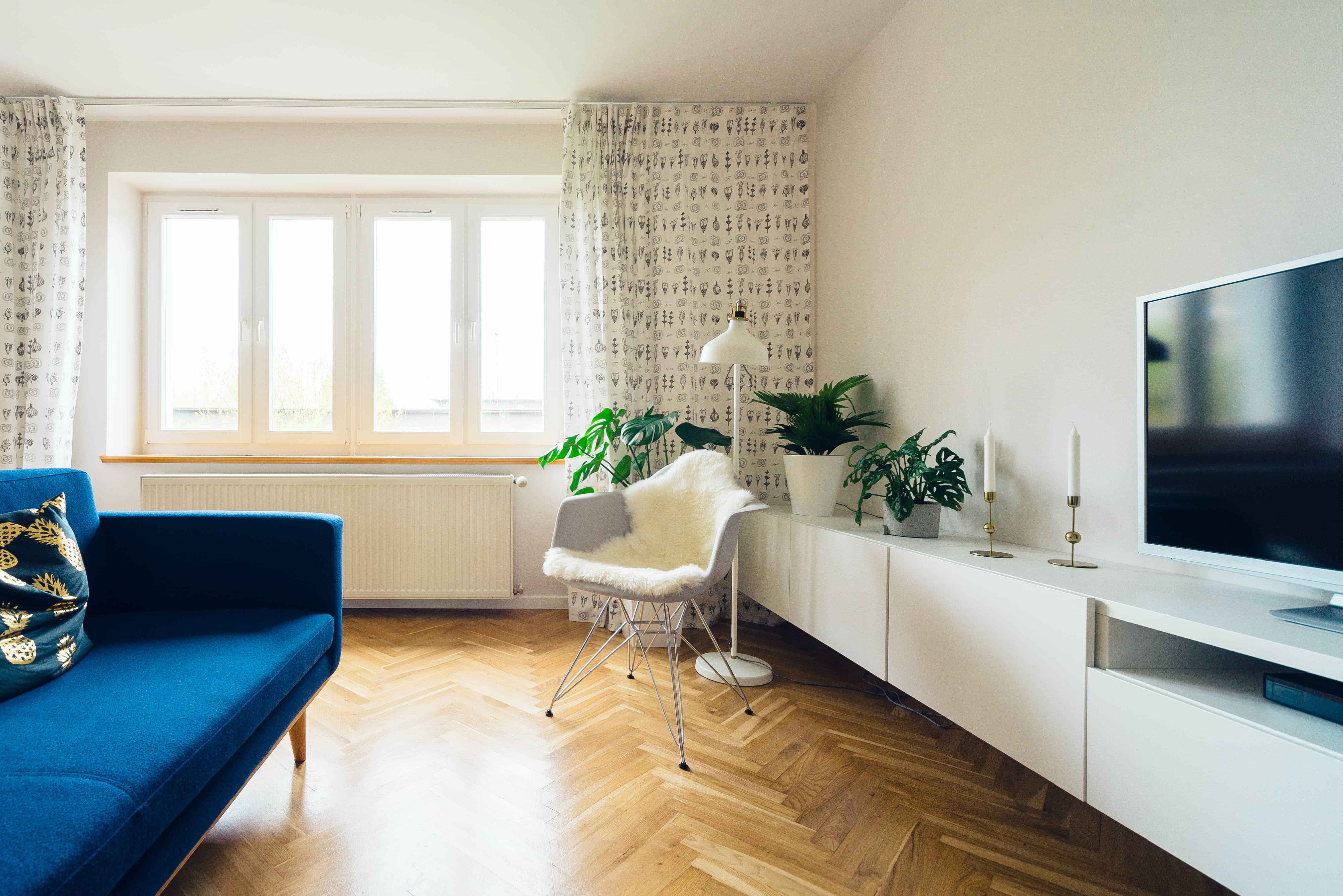 Salon moderne avec canapé bleu et meuble TV.