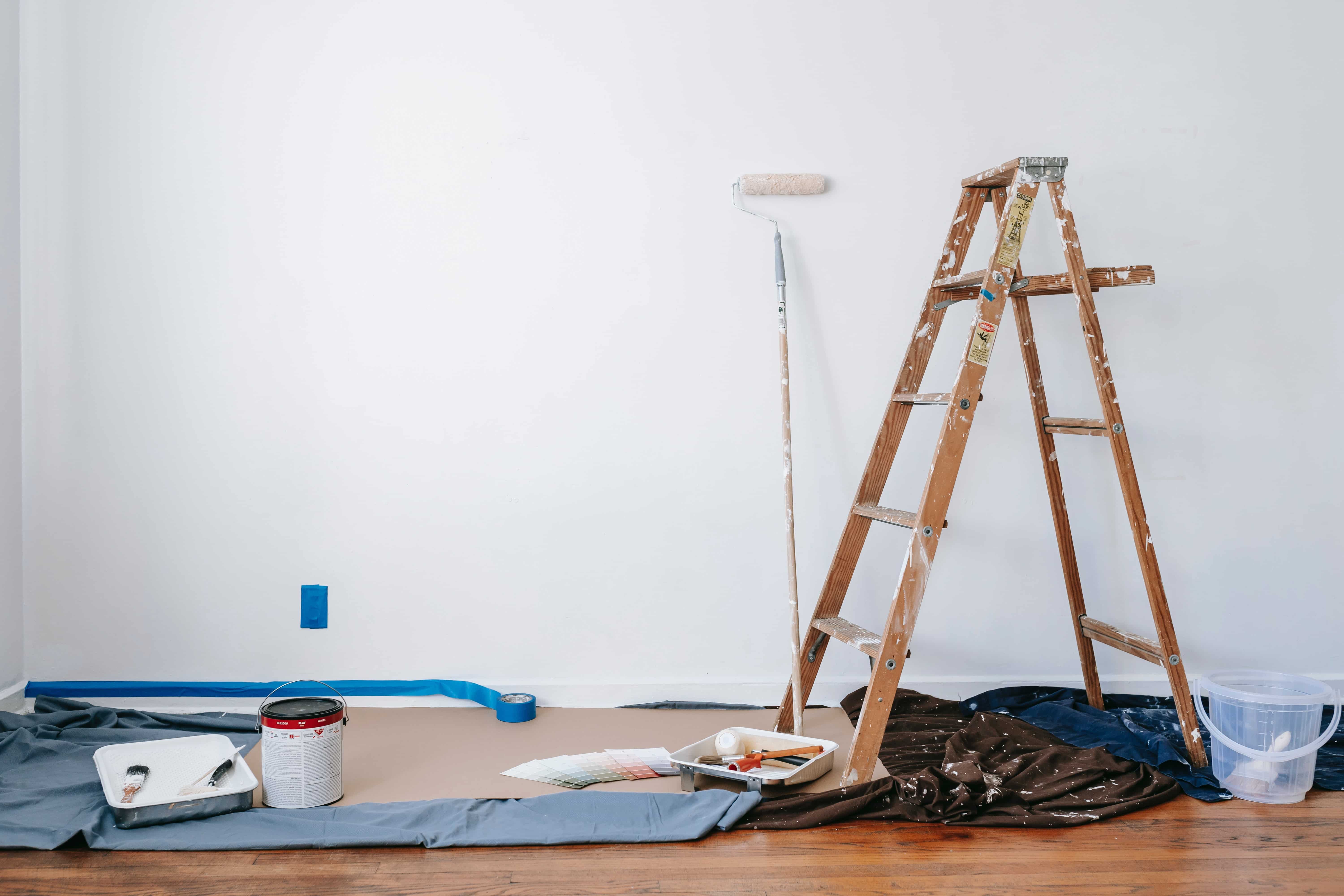 Mur en train d'être peint avec une échelle et des outils de peinture
