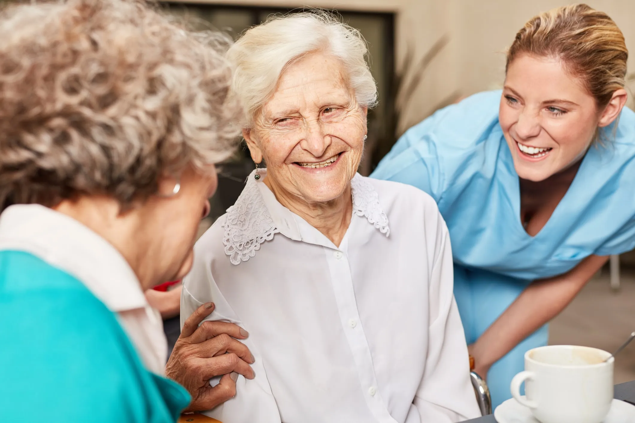 Symbolbild: Eine Pflegekraft und eine Seniorin lachen gemeinsam
