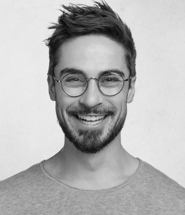 Lachender Mann mit Brille im grauen T-Shirt