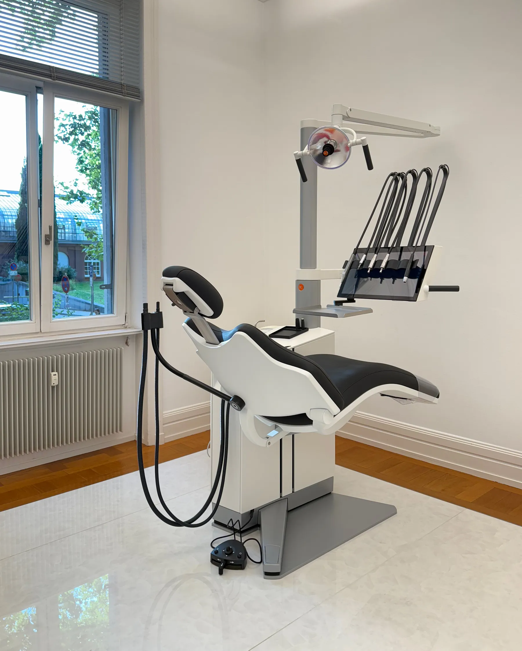 Behandlungszimmer mit Behandlungsstuhl am Fenster