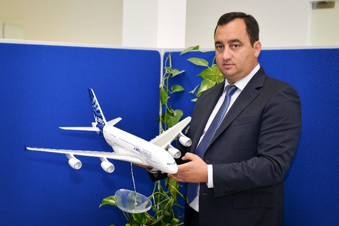Retrato de Filipe Gomes, CEO da Aerojob. Na foto ele segura uma pequena réplica de avião