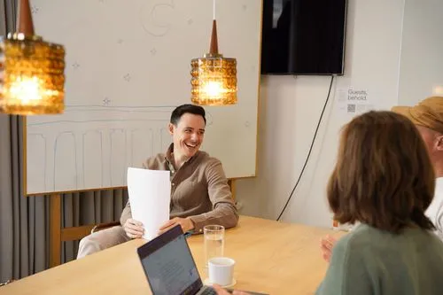 A Refined employee discussing with colleagues.