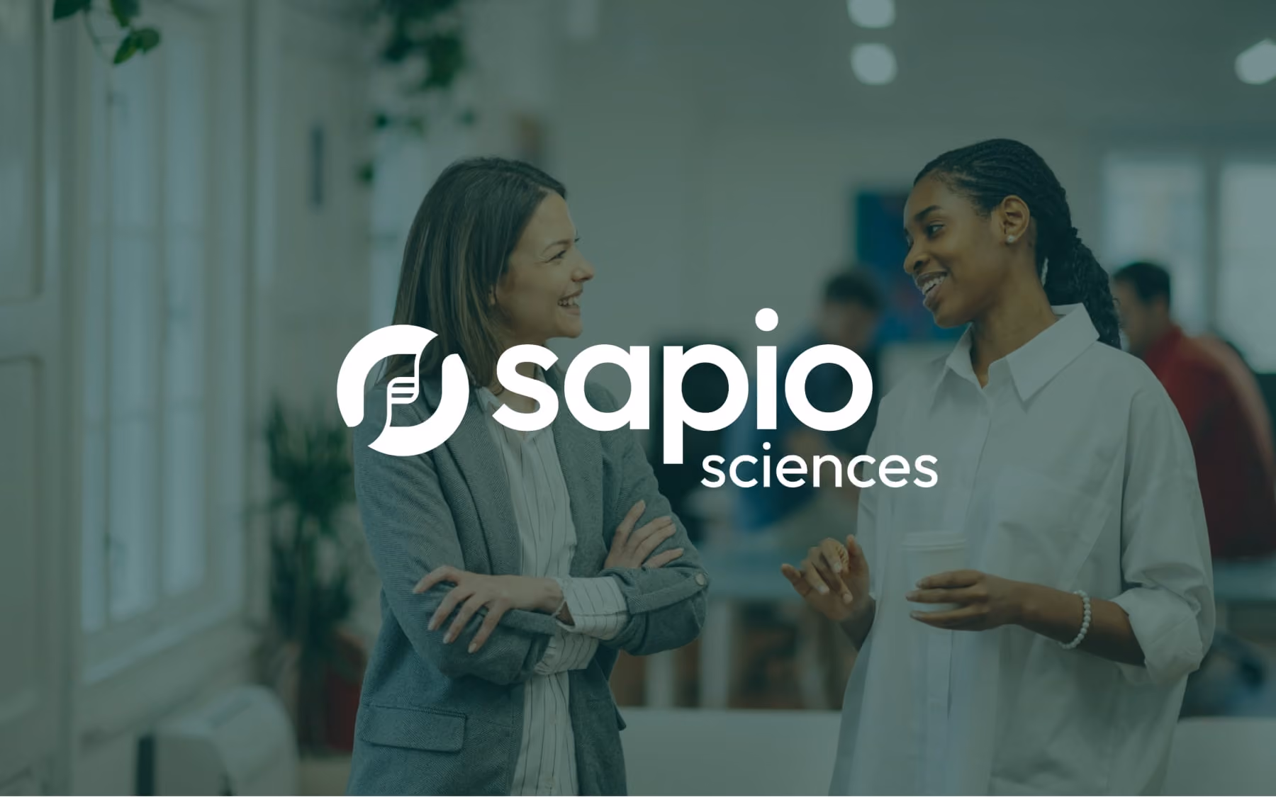 The Sapio Sciences logo against an image background with a dark green tint overlay.