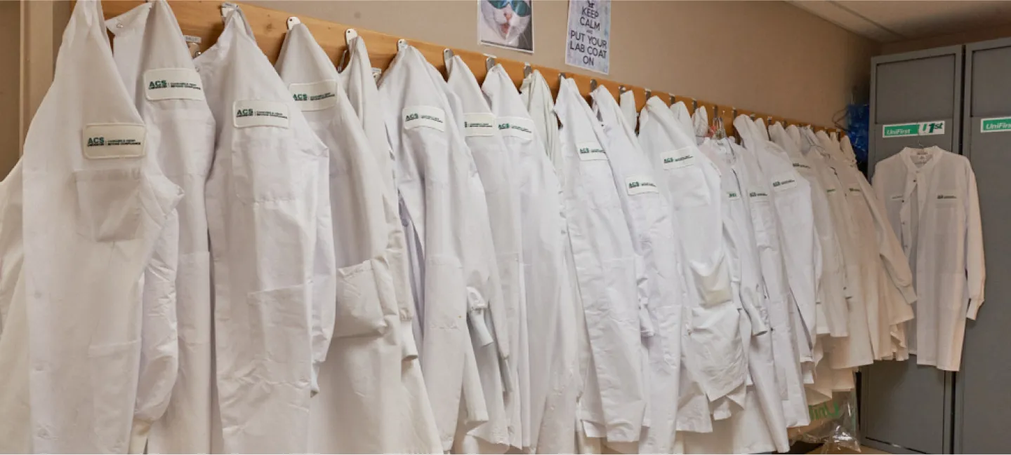 Locker room of CBD experts with collection of lab coats on a rack