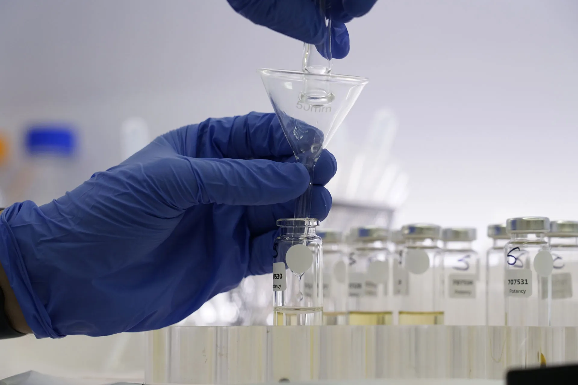 A scientist transferring CBD oil over to a vial for potency testing