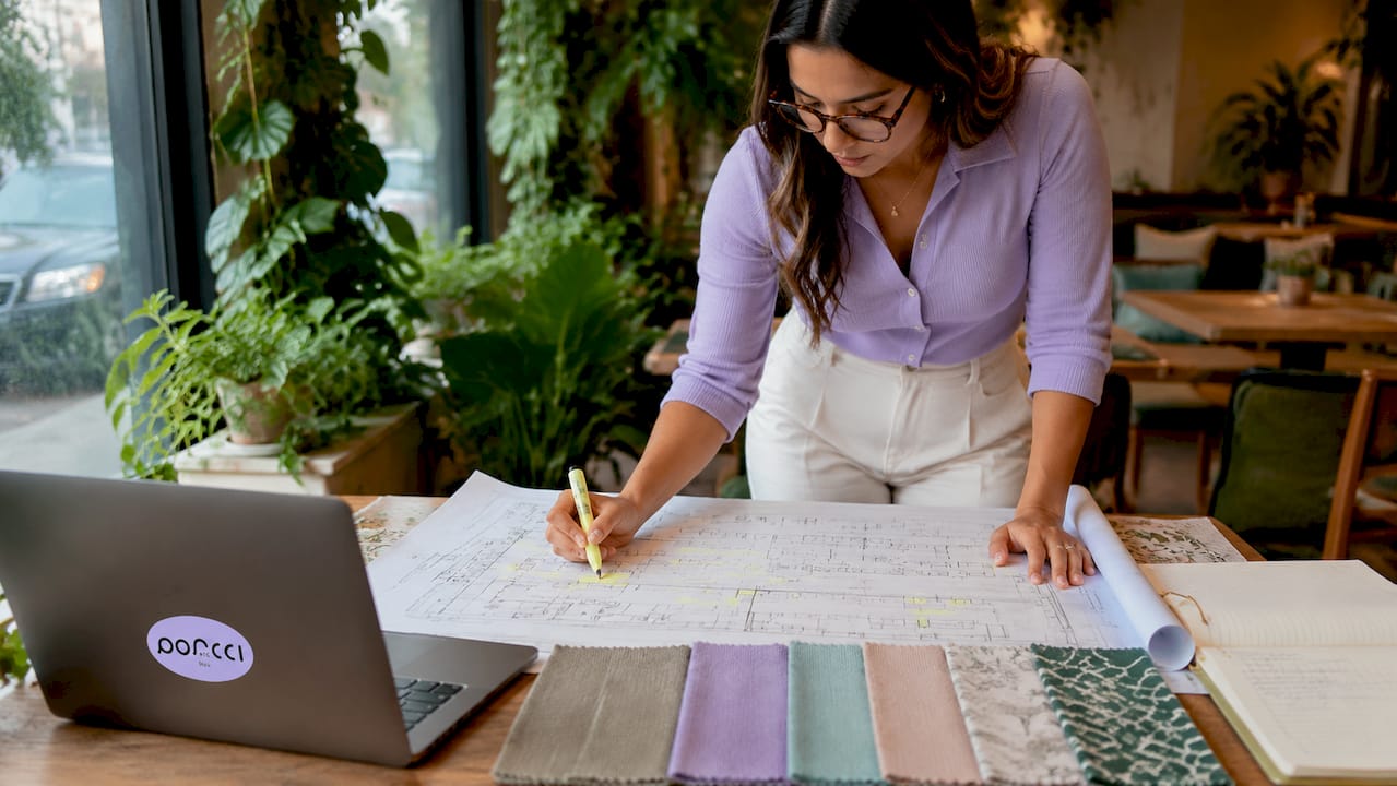 Event planner marking venue floor plan at home