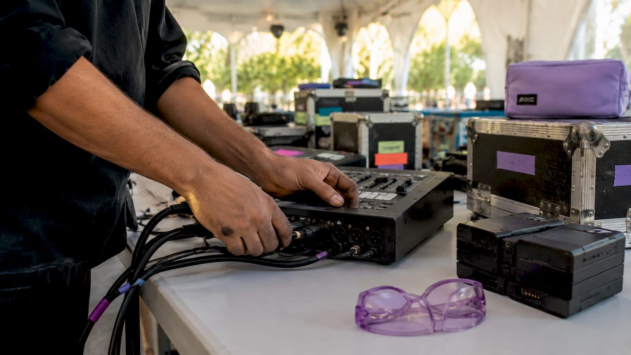 Hands connecting cables on lighting console