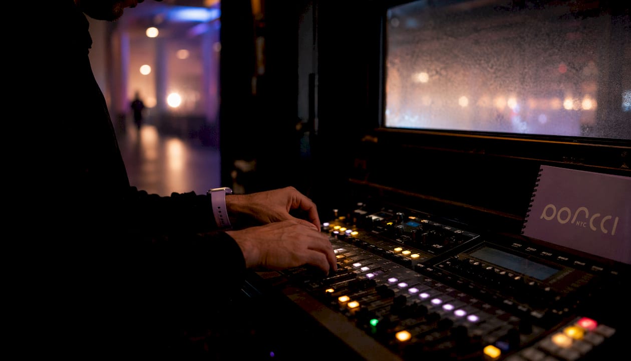 Technician adjusting colored lighting controls at event