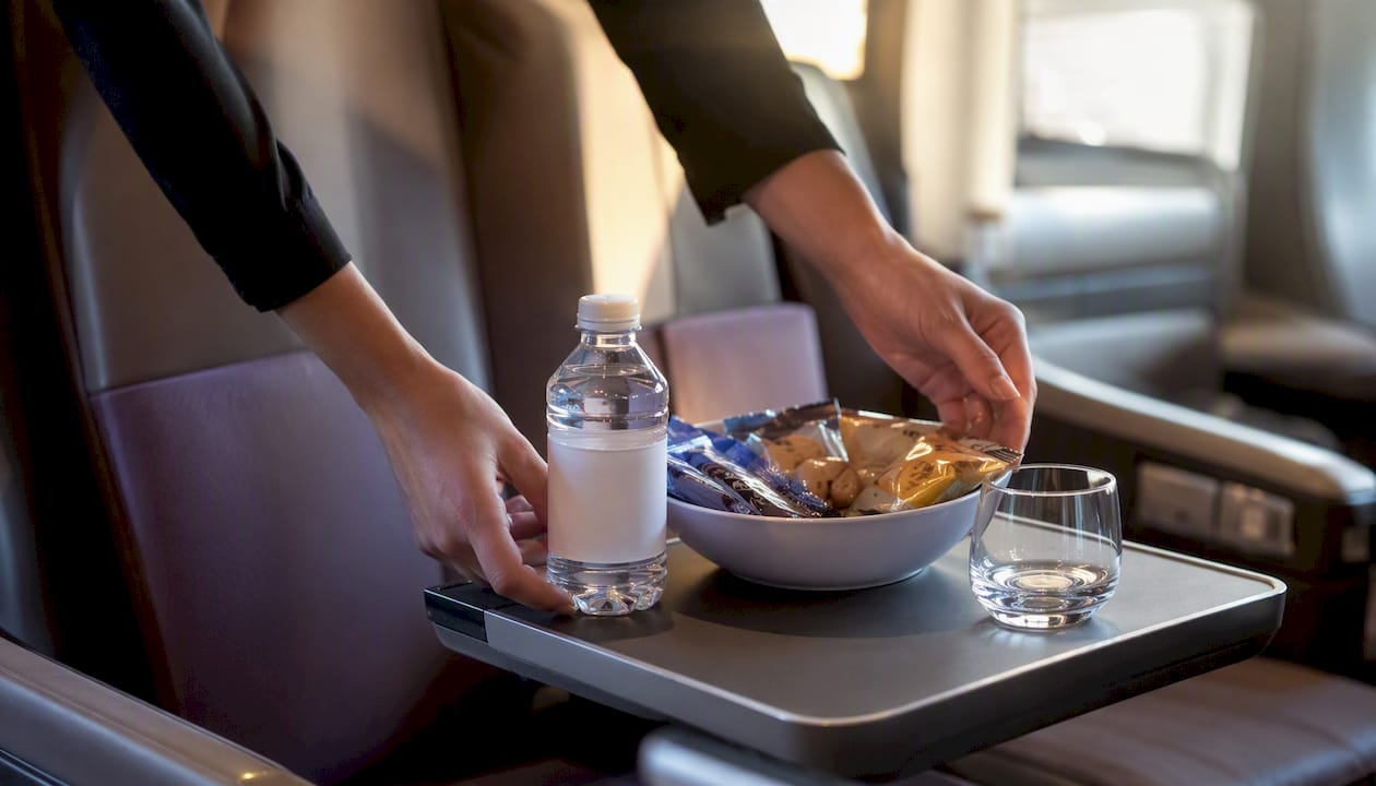 Hand setting refreshments on coach tray during event transfer