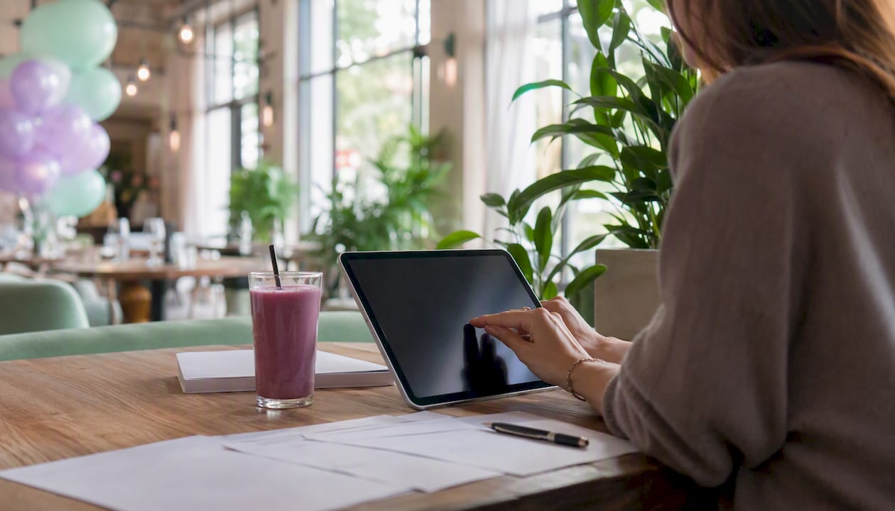 Hand writing notes on tablet at event planning desk