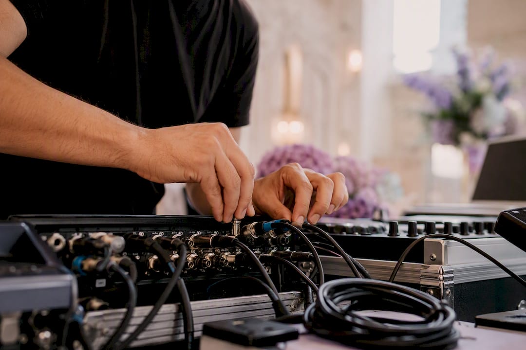 Hands connecting DJ audio cables at wedding