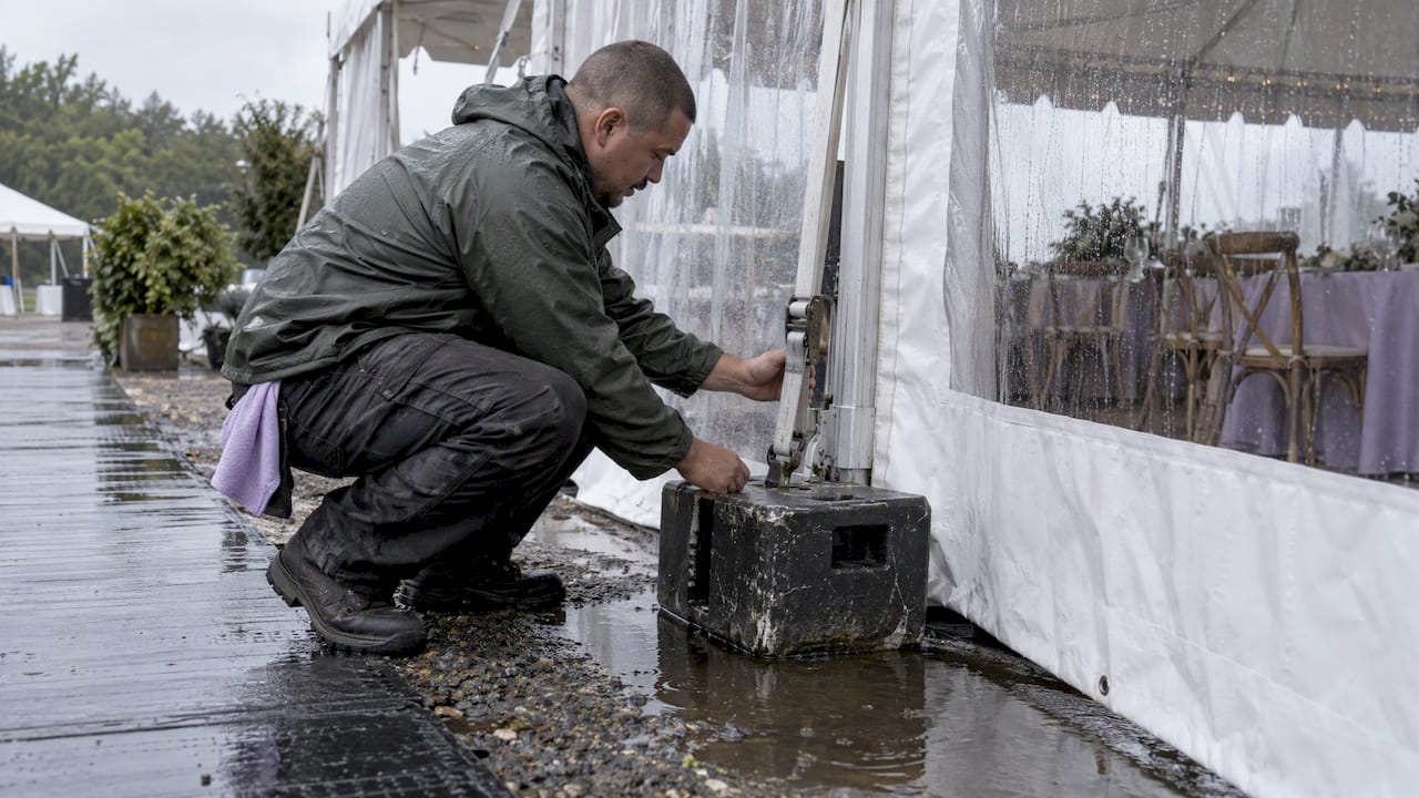 Worker checking anchored wedding tent