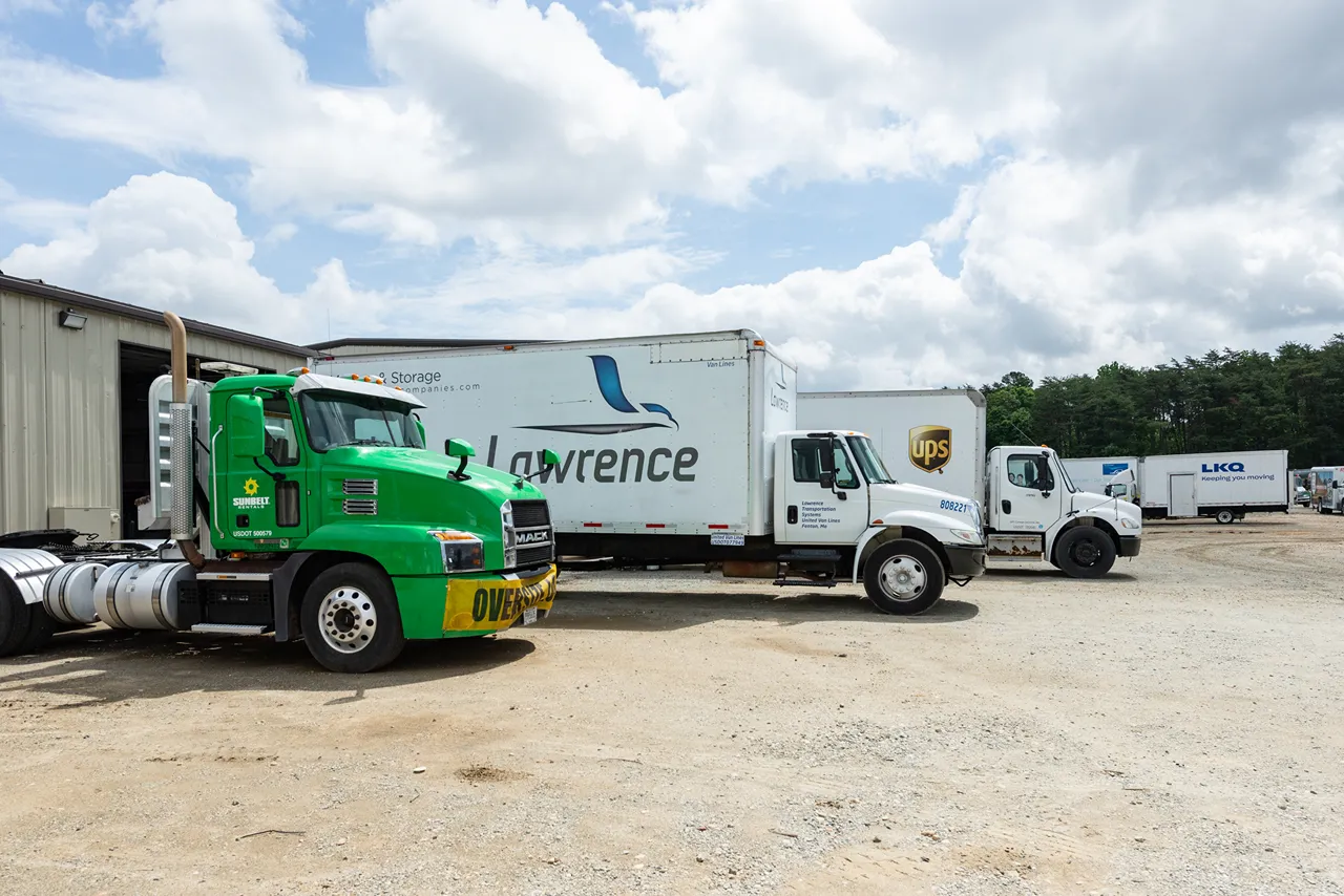 Smart Maintenance Checkpoint for Greensboro fleets with Mack and box trucks lined up outside a heavy-duty repair shop.