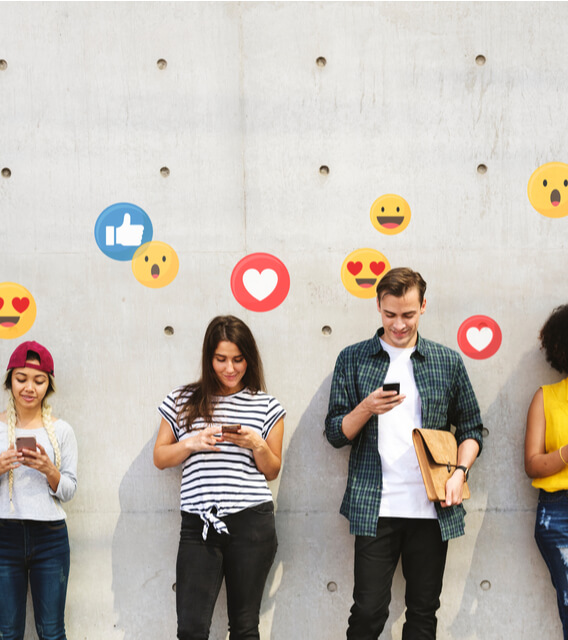 Group of young adults using smartphones with floating social media reaction icons, symbolizing digital engagement and social media interaction.