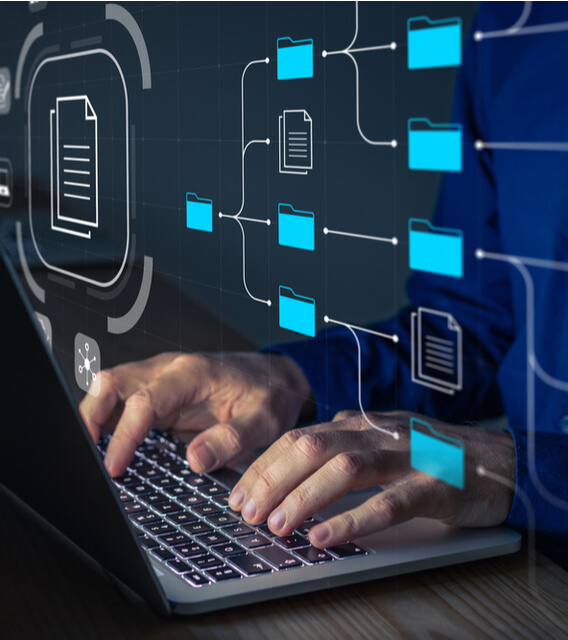 Person typing on a laptop with floating digital folder icons, symbolizing data extraction services and automated information retrieval.