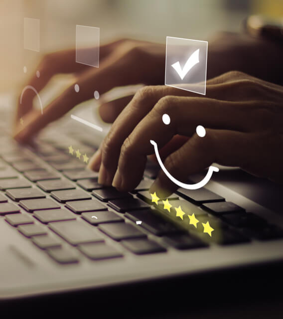 Person typing on laptop with digital smiley and star rating icons, symbolizing customer feedback and satisfaction evaluation.