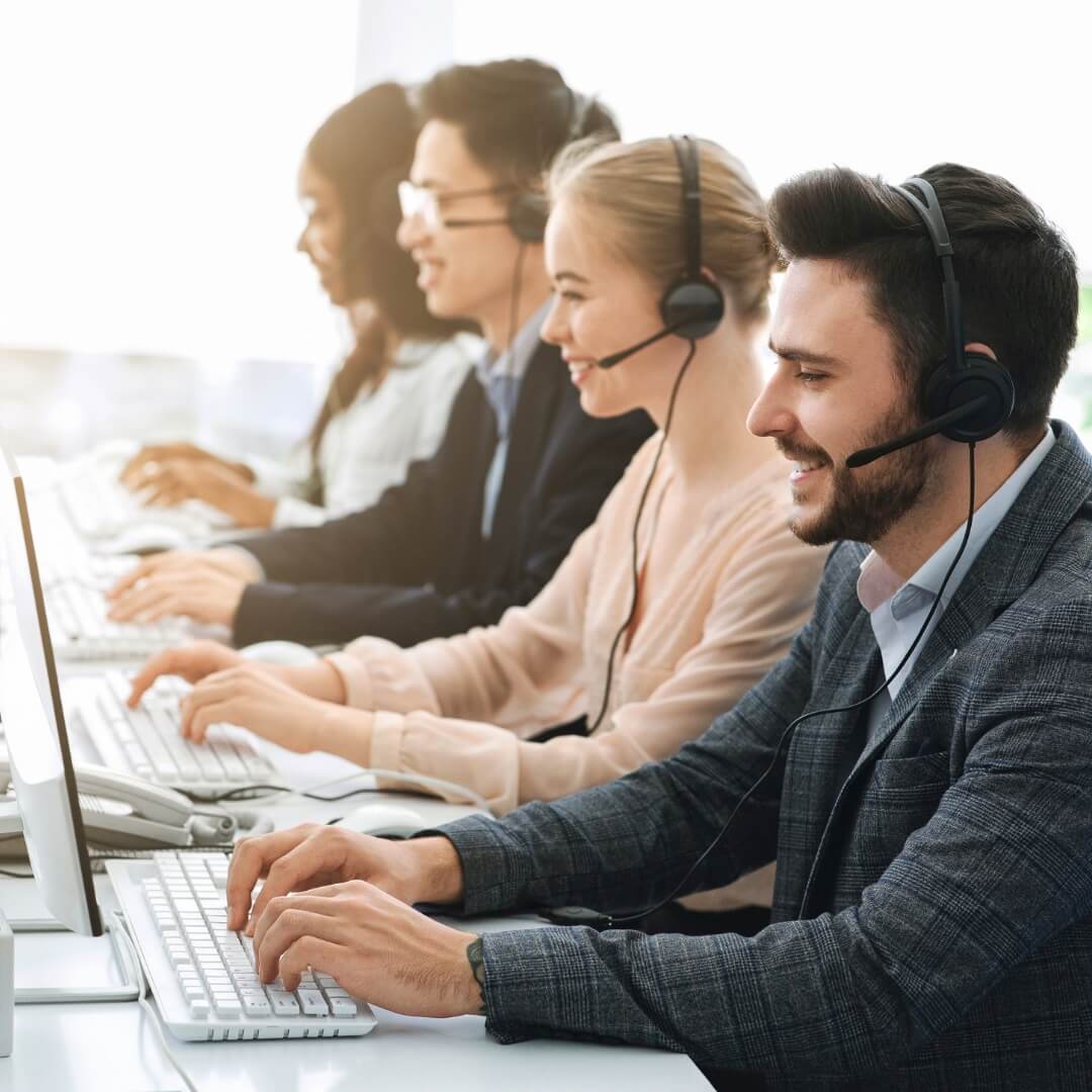 Team of professionals with headsets working on computers in a modern office, representing back-office operations and customer support services.