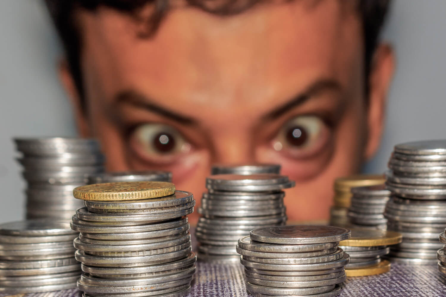 Persona mirando fijamente un montón de monedas