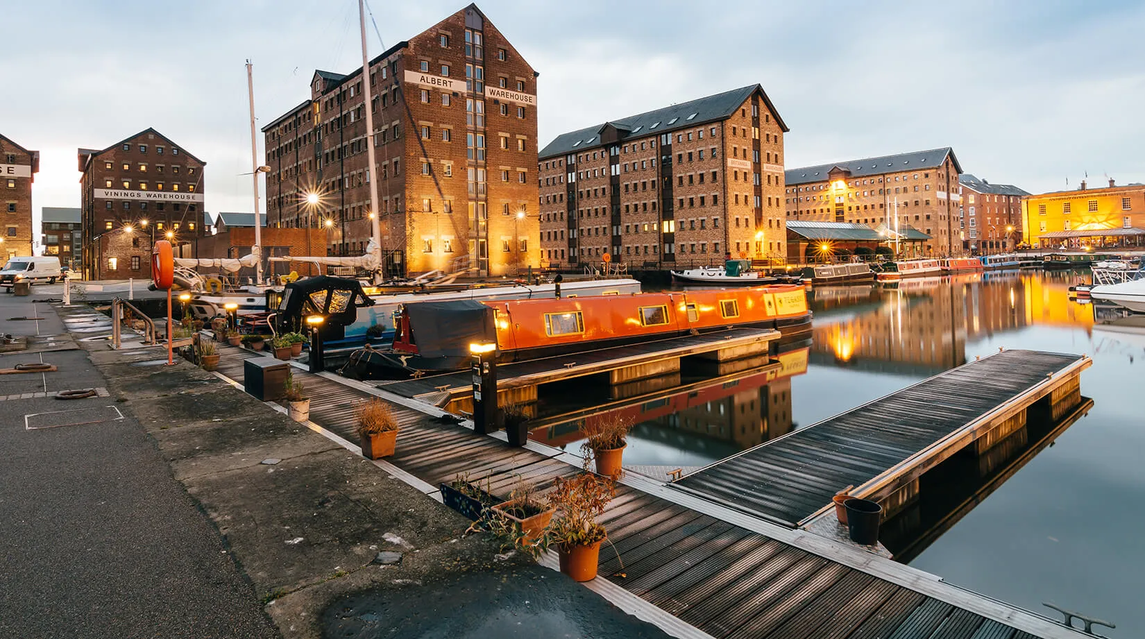 Gloucester Docks and the historic Albert Warehouse at dusk, within AMW Couriers' Gloucester delivery coverage area.