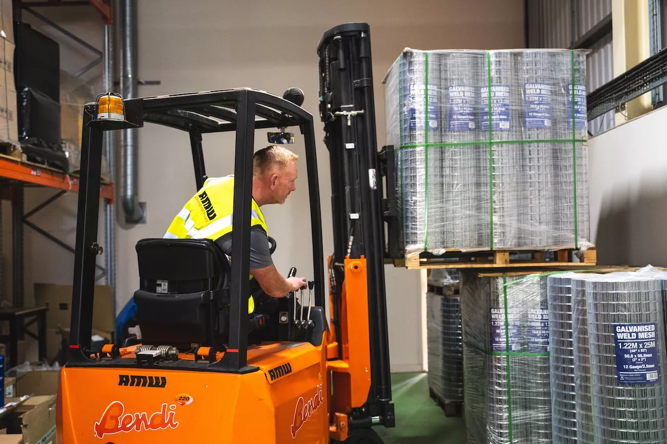 AMW Couriers operator using a forklift to handle a wrapped pallet ready for UK delivery